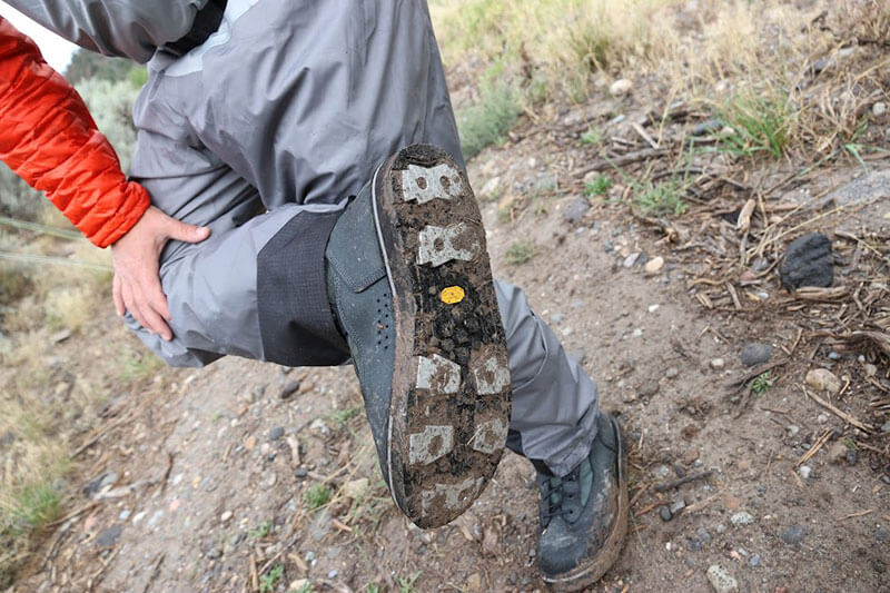 fisherman using patagonia wading boots and looking at the tread