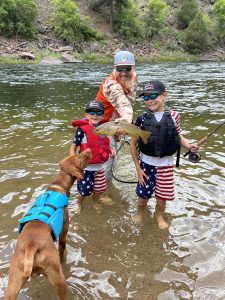 So, you’ve decided to teach your kids to fly fish., father and two sons fly fishing with dog in river